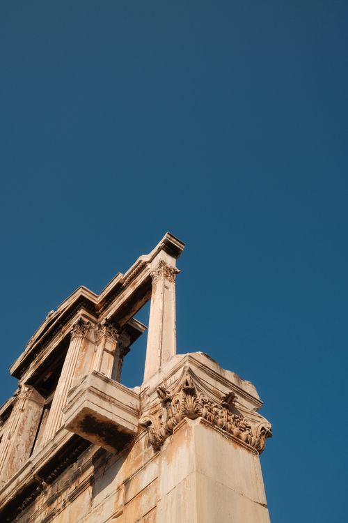 Free Close-up of ancient Greek ruins showcasing intricate stonework and columns against a clear blue sky. Stock Photo
