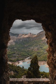 Beautiful mountainous landscape from a stone window at Guadalest, Spain.