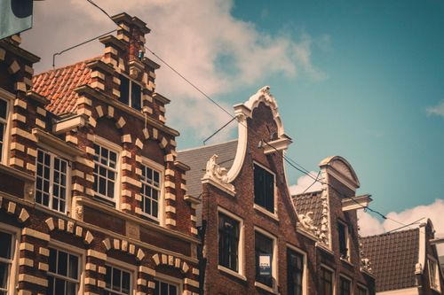 Free Quaint Dutch gabled houses with blue sky in Amsterdam, Netherlands. Stock Photo
