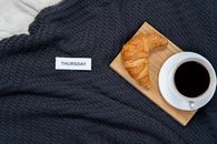 新的一天，从一份铺在温暖毛毯上的羊角面包和咖啡组成的舒适早餐开始