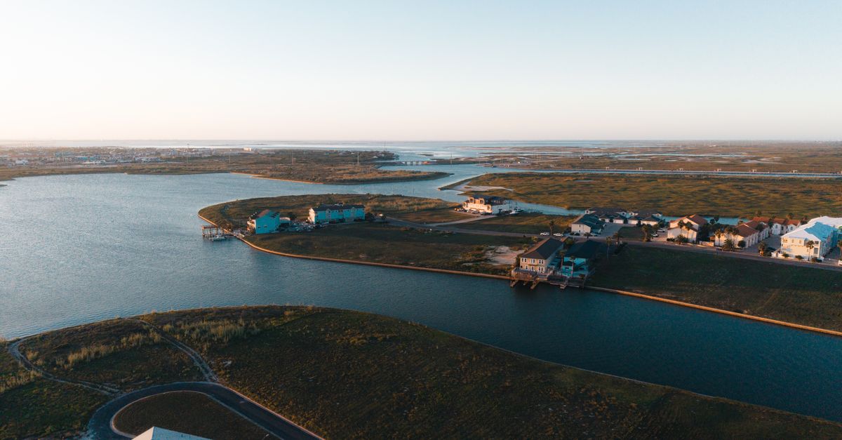 Stunning aerial view of waterfront homes in Corpus Christi, Texas at sunset, highlighting coastal beauty.