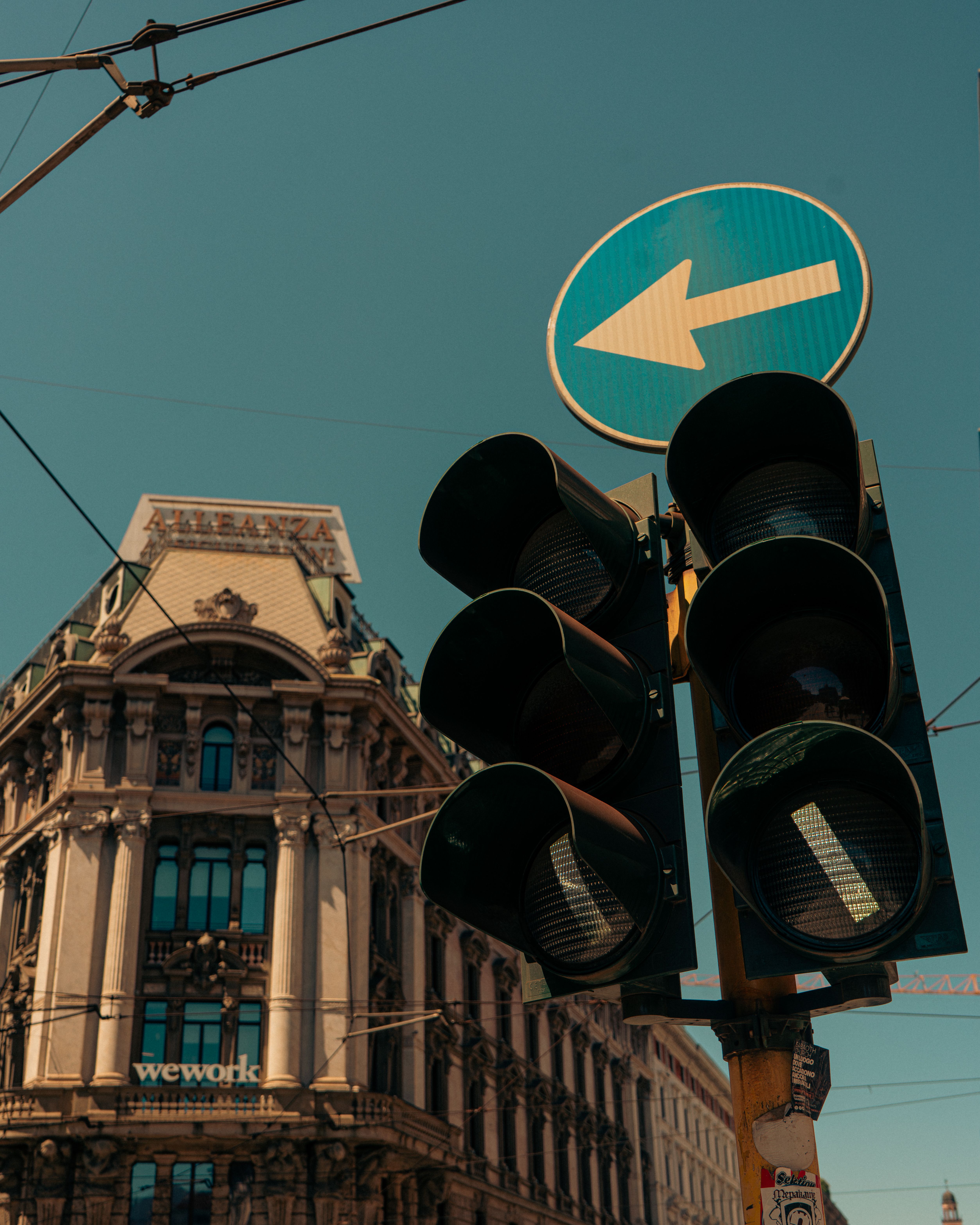 Traffic light and historic architectural building under clear blue sky in city setting.