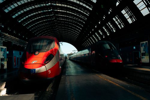 Free Dynamic view of high-speed trains in iconic Milan Central Station under a glass roof. Stock Photo