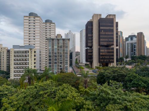 Free A view of Belo Horizonte, Brazil's cityscape with skyscrapers and green foliage against a cloudy sky. Stock Photo