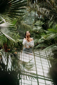 温室的热带植物丛中，一名女子优雅站立，营造出宁静的氛围