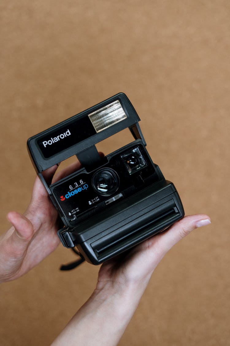 Black Polaroid Instant Camera On Persons Hand