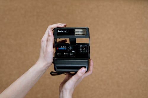 Person Holding Black Polaroid Camera