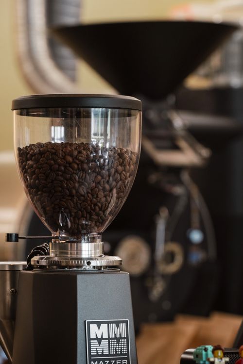Free High-quality photo of coffee grinder with beans, ideal for cafe interiors and coffee-related themes. Stock Photo