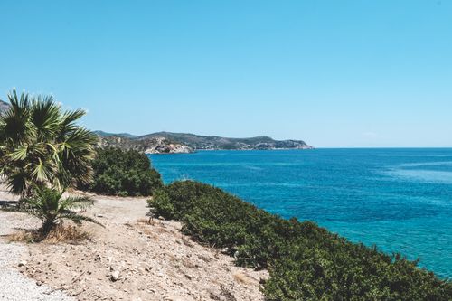 Free Stunning view of a tropical coast with clear blue water under a sunny sky. Stock Photo
