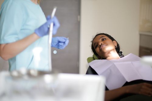 Free Dentist performing checkup on patient in clinic with modern equipment. Stock Photo