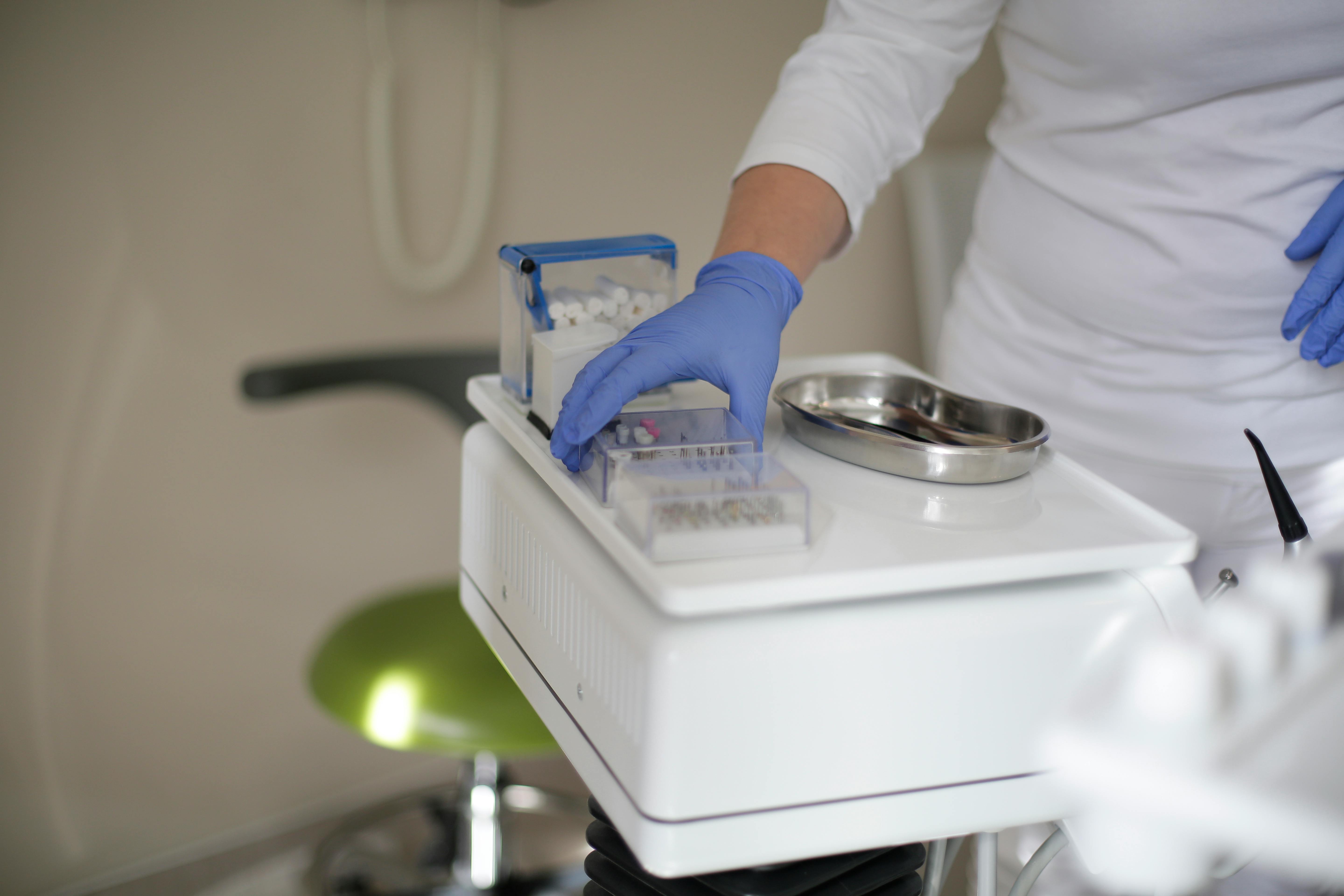 crop dentist preparing bur for dental drill