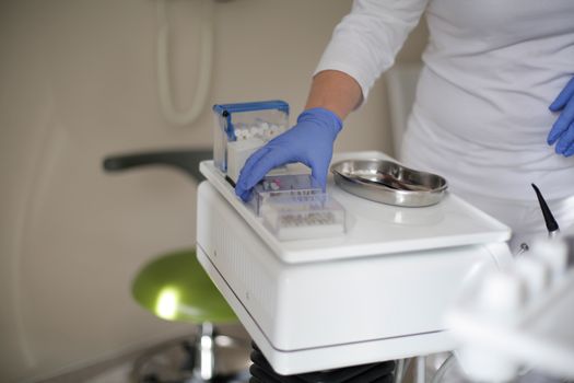 Crop dentist preparing bur for dental drill
