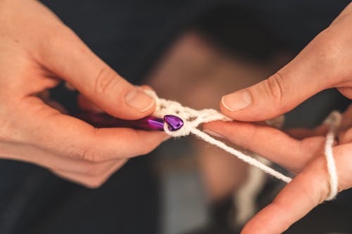 Person Holding A Crochet Hook 