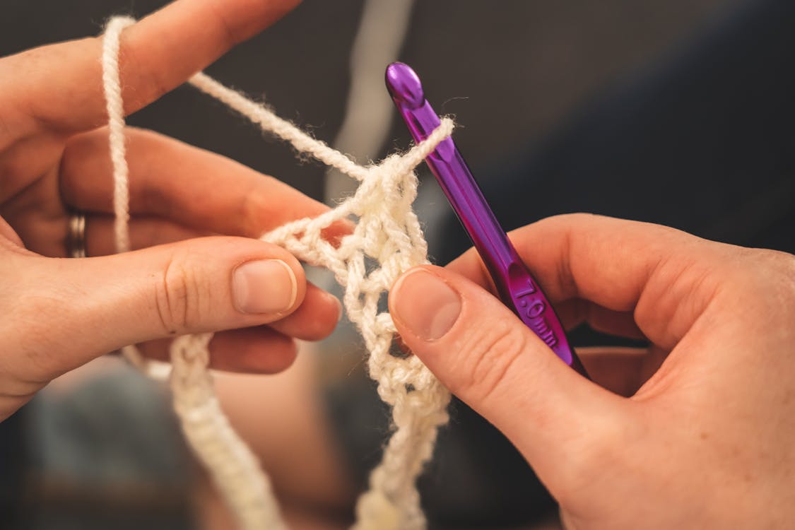 Free Person Holding Purple Crochet Hook and White Yarn Stock Photo