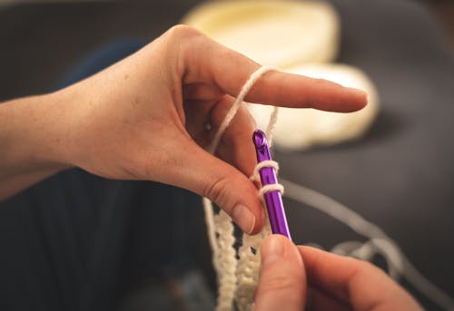 Person Holding Purple Crochet Hook