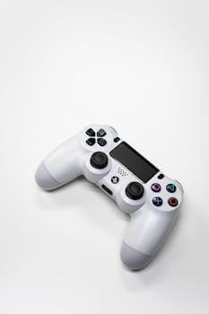Minimalist image of a white gaming console controller isolated on a bright white background.
