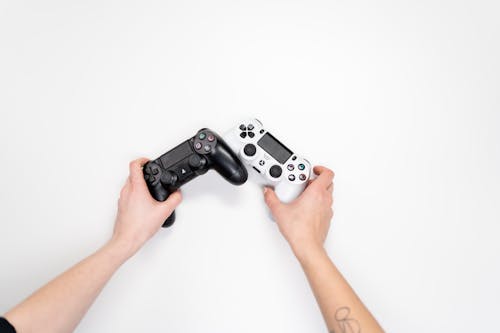 Free Person Holding Black and White Sony Ps 4 Controller Stock Photo