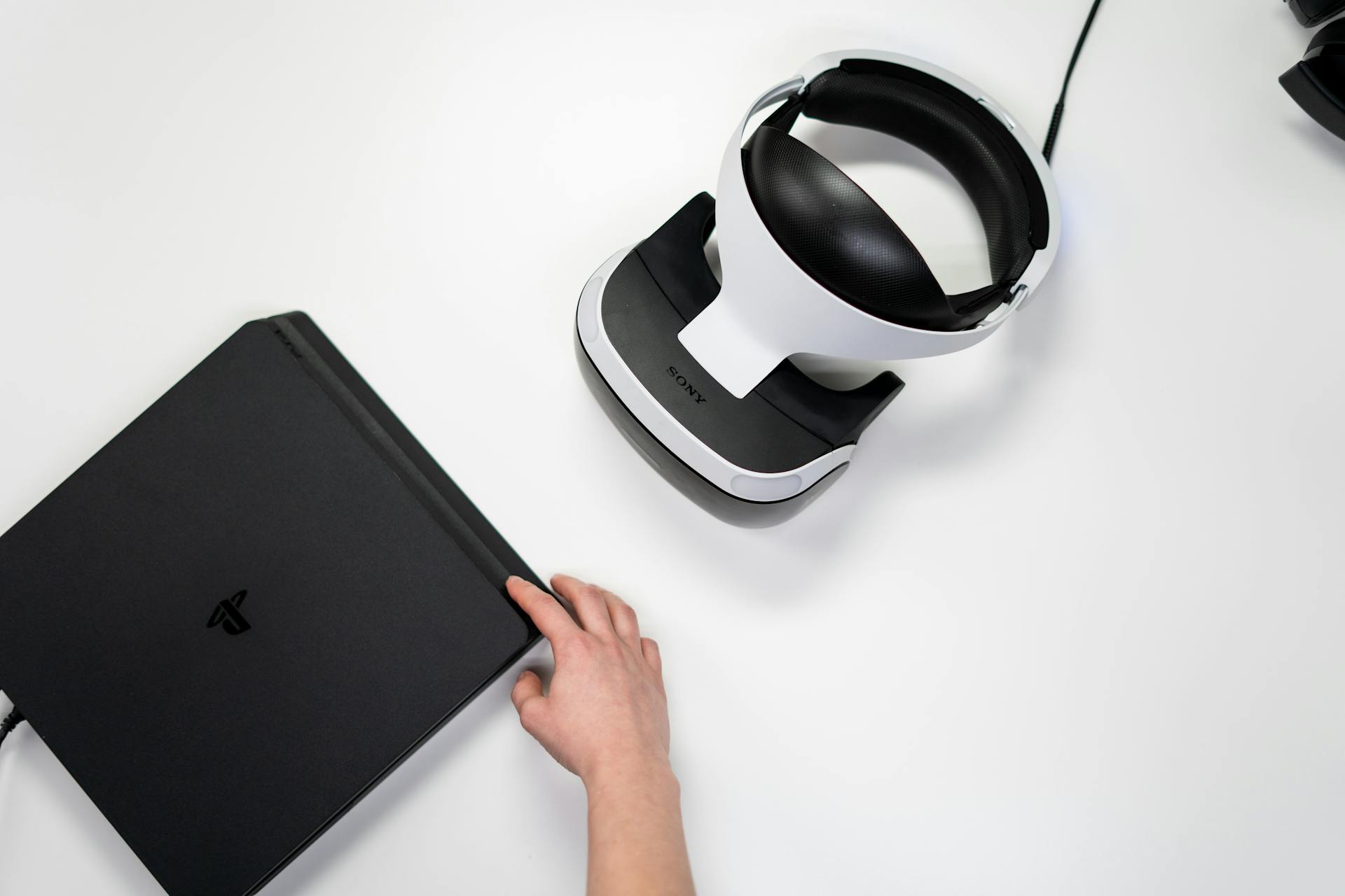 Experience modern gaming with a console and VR headset in a sleek flat lay.