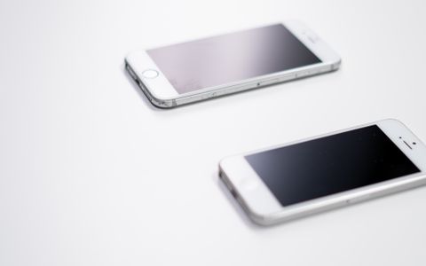 Móvil, tableta y dispositivos sobre una mesa blanca