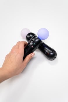 Close-up of hand holding interactive motion controllers for immersive gaming.
