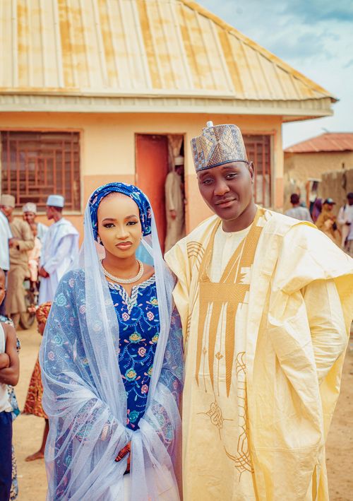 Free A couple in traditional Nigerian attire pose during an outdoor wedding ceremony. Stock Photo