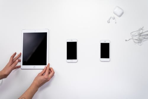 Person Holding White Ipad Beside White Ipad