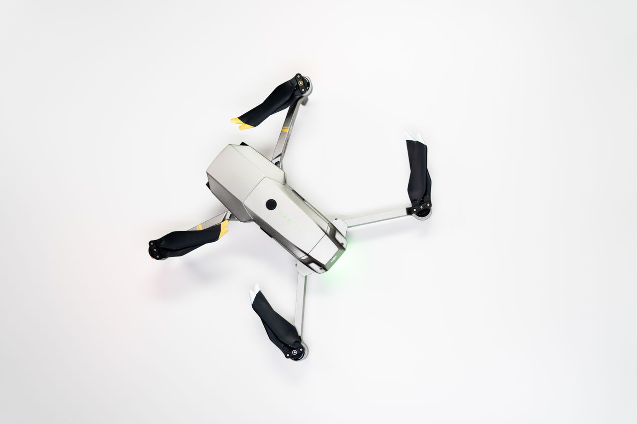 overhead shot of a quadcopter drone with folded propellers on a clean