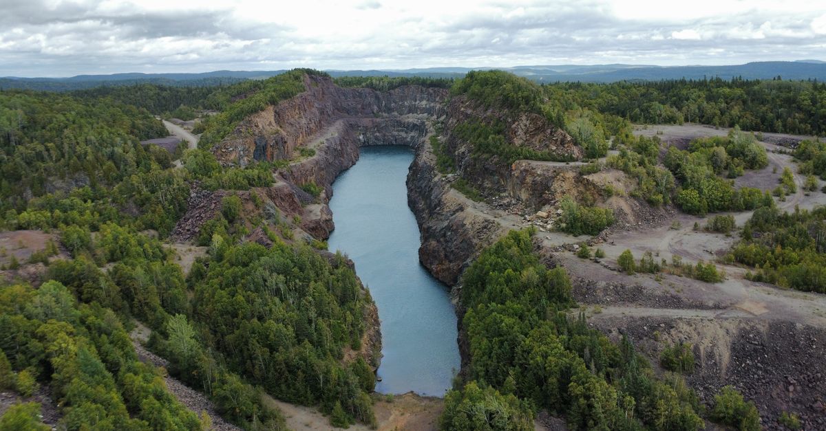 Aerial view of a scenic tailing pond amidst lush greenery in Wawa, Ontario, Canada.