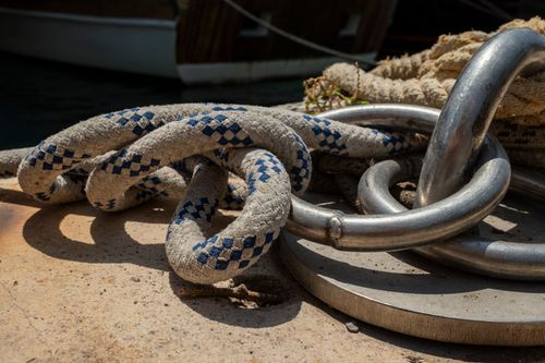 Free A detailed view of weathered rope and metal ring on a dock, evoking a nautical and rustic ambiance. Stock Photo