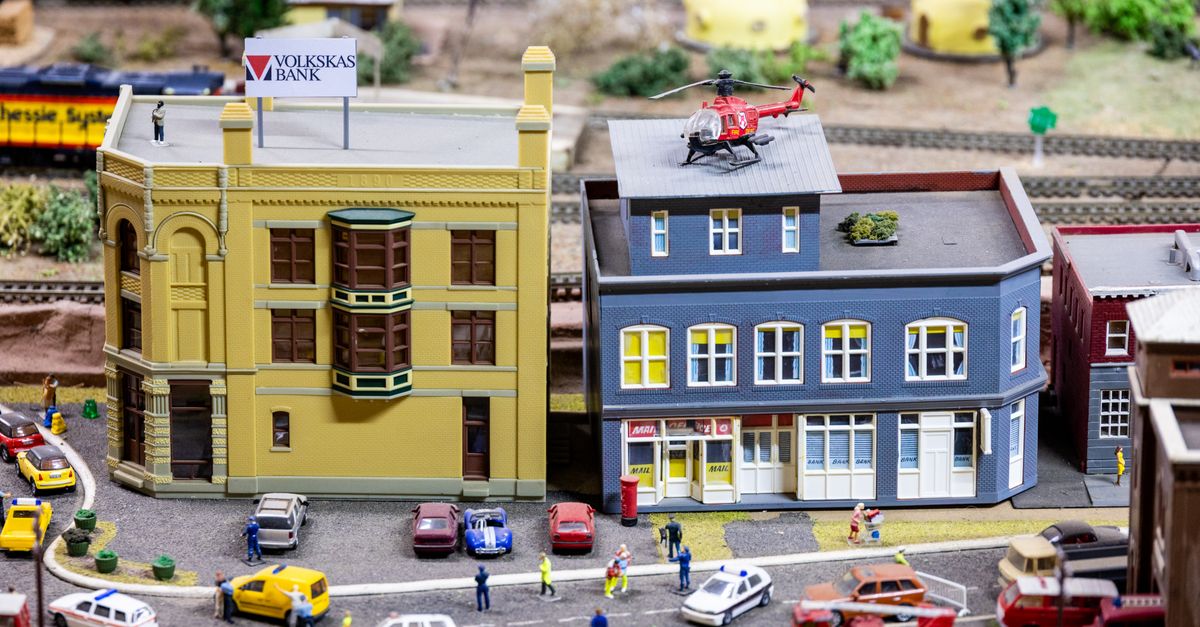 Intricate miniature city scene with model buildings, vehicles, and figures creating a lively urban setting.