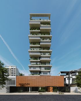 Front view of a contemporary building with lush green balconies under a clear blue sky.