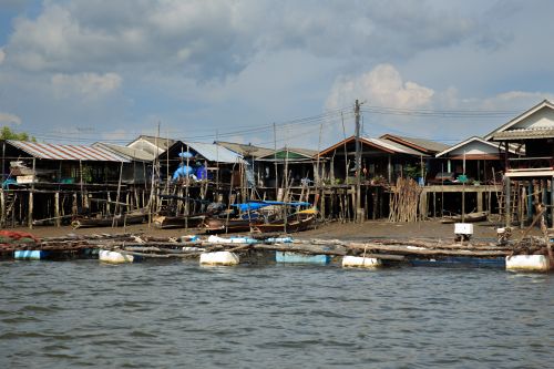 Free Charming stilt houses line the water in a rustic fishing village. Capture of daily village life. Stock Photo