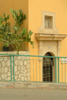 Quiet street view of Provence with cactus and warm architecture.