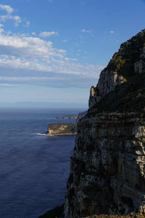 Free Stunning rocky cliffs at Cape Raoul, Tasmania overlooking the ocean under a clear blue sky. Stock Photo