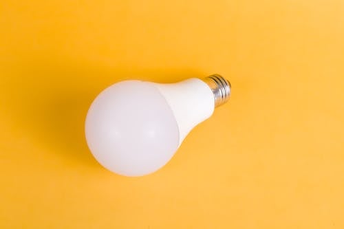 White Light Bulb On Yellow Surface