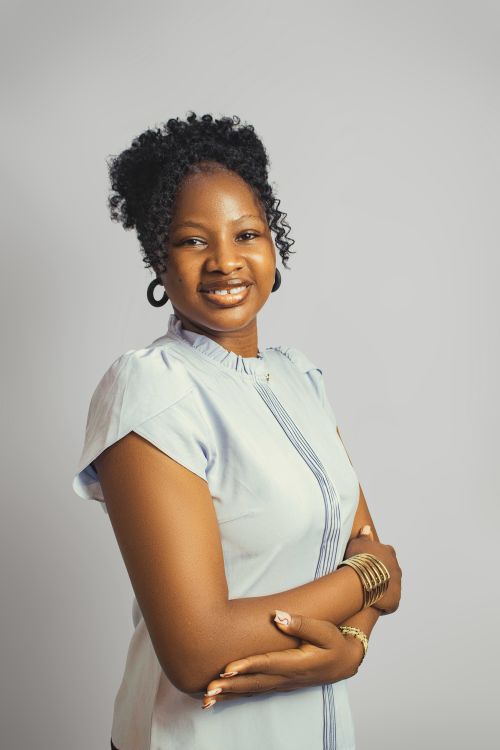 Free Studio portrait of a smiling woman with curly hair and elegant attire, exuding confidence and beauty. Stock Photo