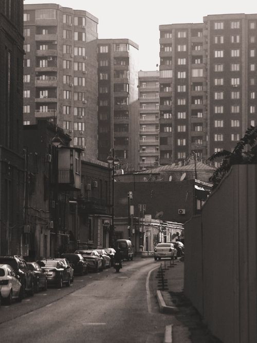 Free Sepia-toned urban street surrounded by high-rise buildings. Stock Photo