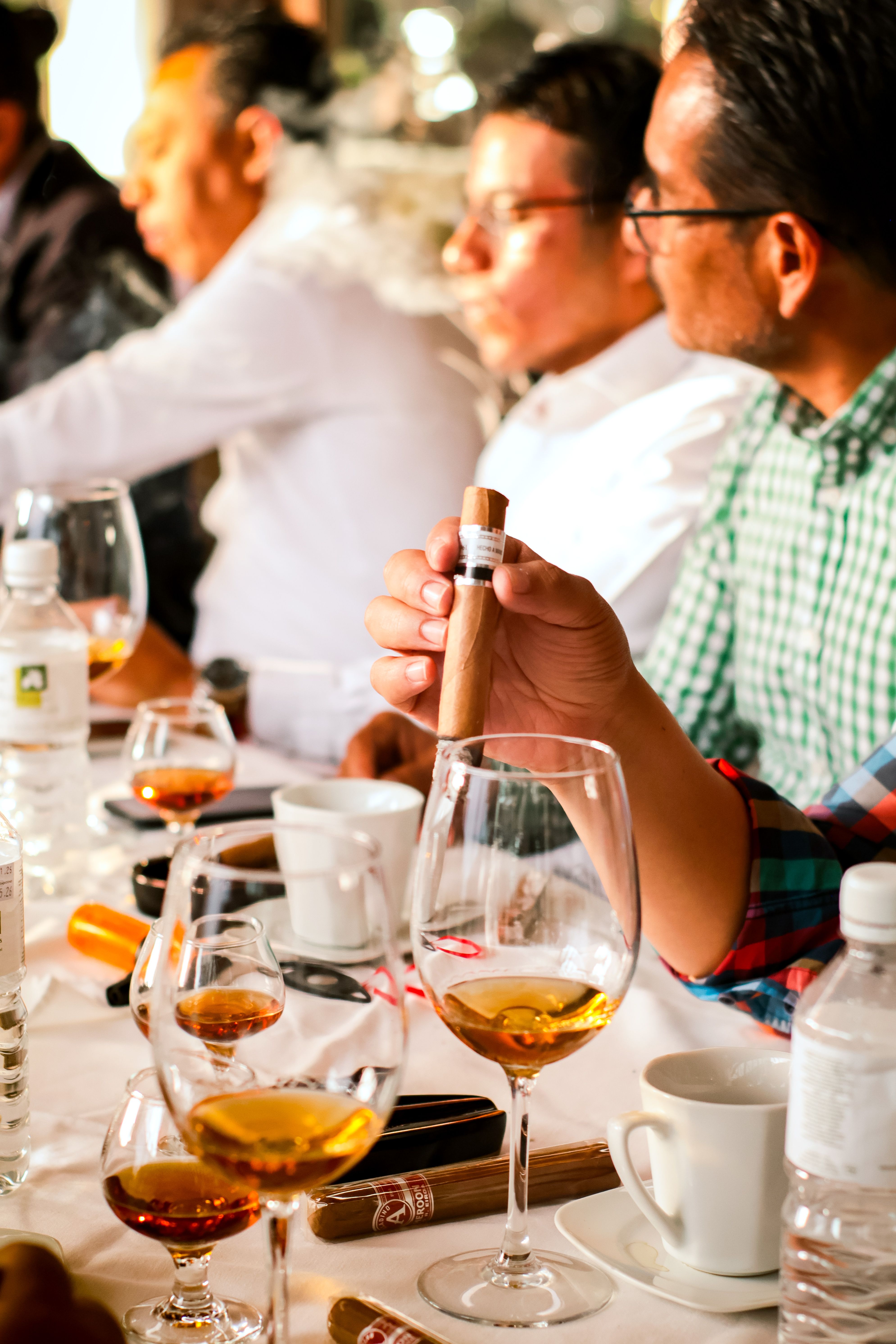 Group of men enjoying cigars and drinks at a social event in Huamantla, Tlaxcala, México.