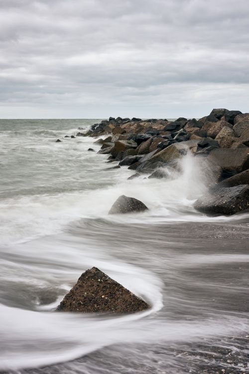 Free A dynamic seascape with waves crashing on rocky shores in Trans, Denmark. Stock Photo