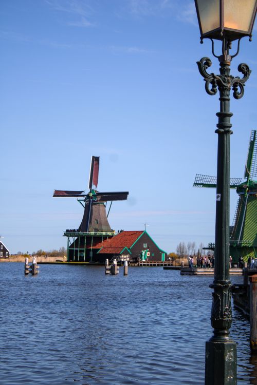Free Picturesque view of traditional windmills by the water in Zaanse Schans, Netherlands. Stock Photo