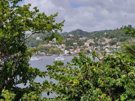 Vibrant view of boats in Samaná Bay surrounded by lush greenery and picturesque hillsides.
