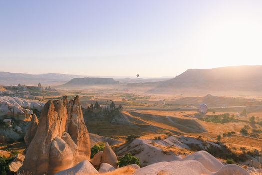 Capture of stunning Cappadocia landscape with hot air balloons at sunrise.