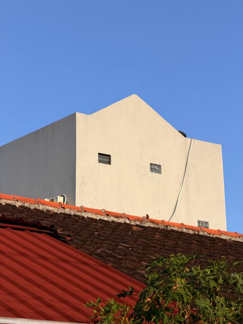 Free A modern minimalist building facade set against a clear blue sky in Jogja, Indonesia. Stock Photo