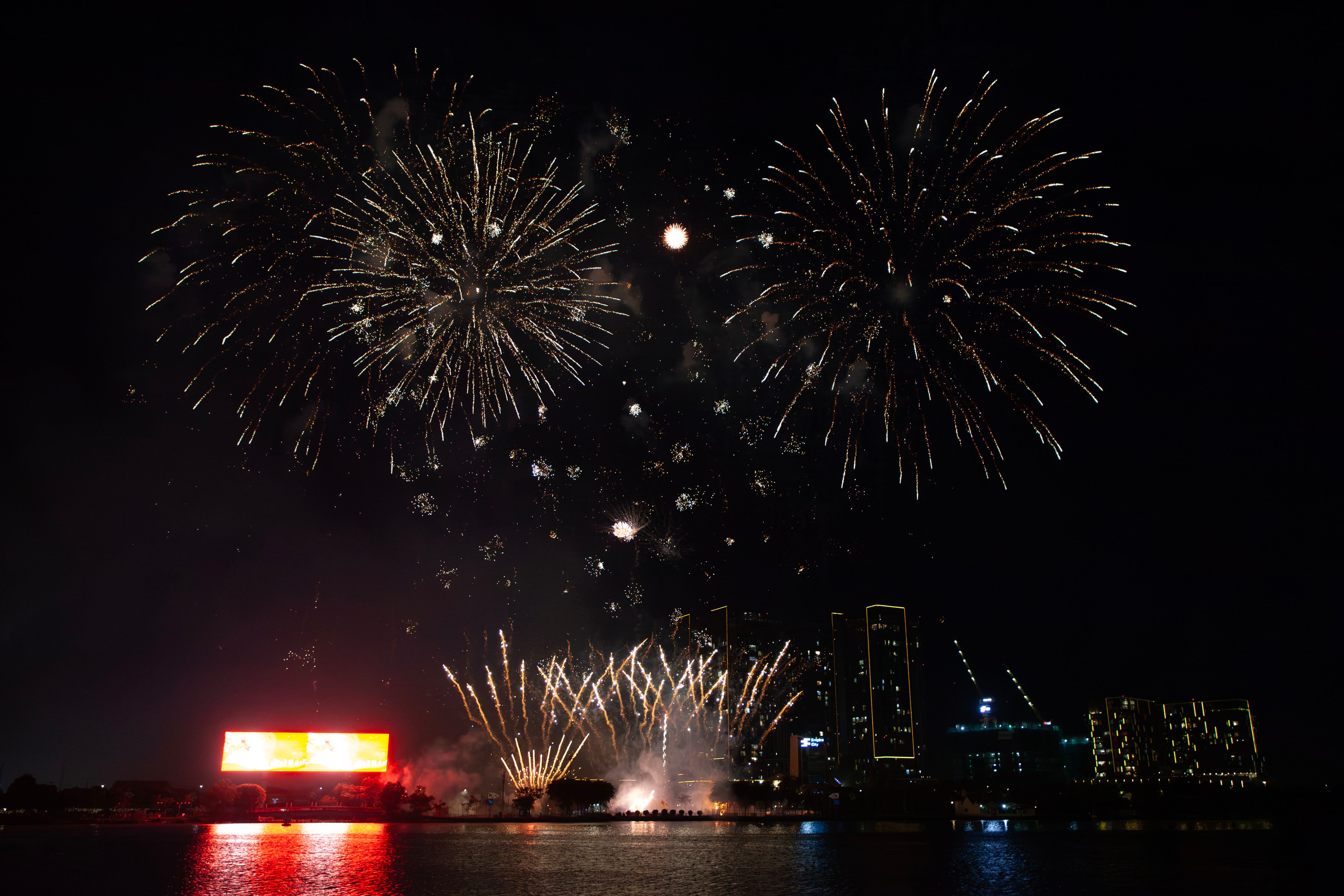 Vibrant fireworks light up the city skyline, creating a dazzling nighttime spectacle.