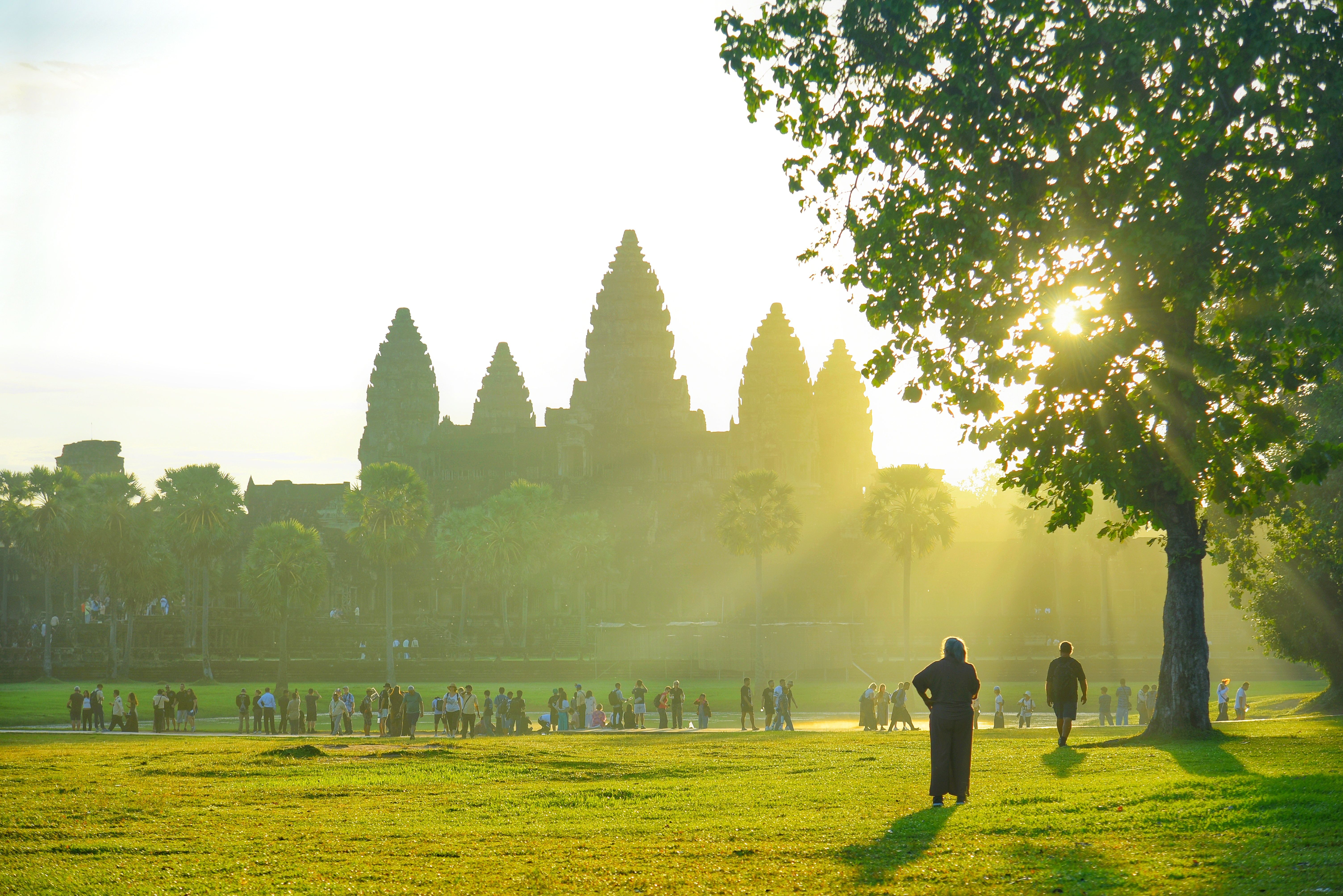 travelers watching the sunrise over ancient archaeological monuments