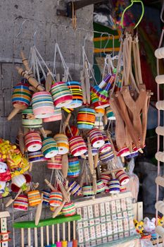 Vibrant display of traditional colorful wooden tops and crafts at a local market.