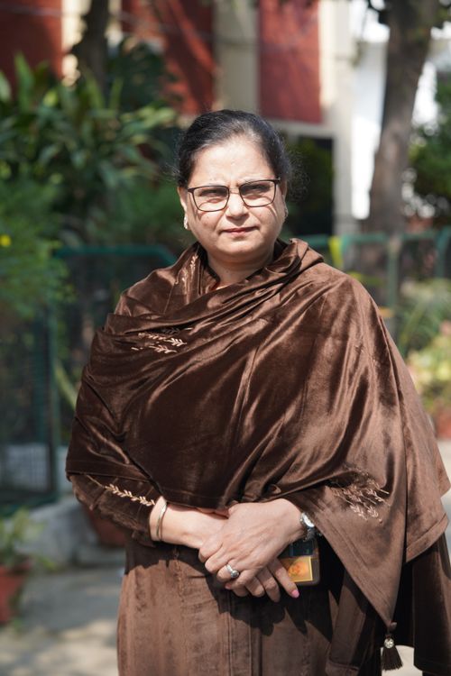 Free A woman in glasses and a brown shawl enjoying a sunny day outside. Stock Photo