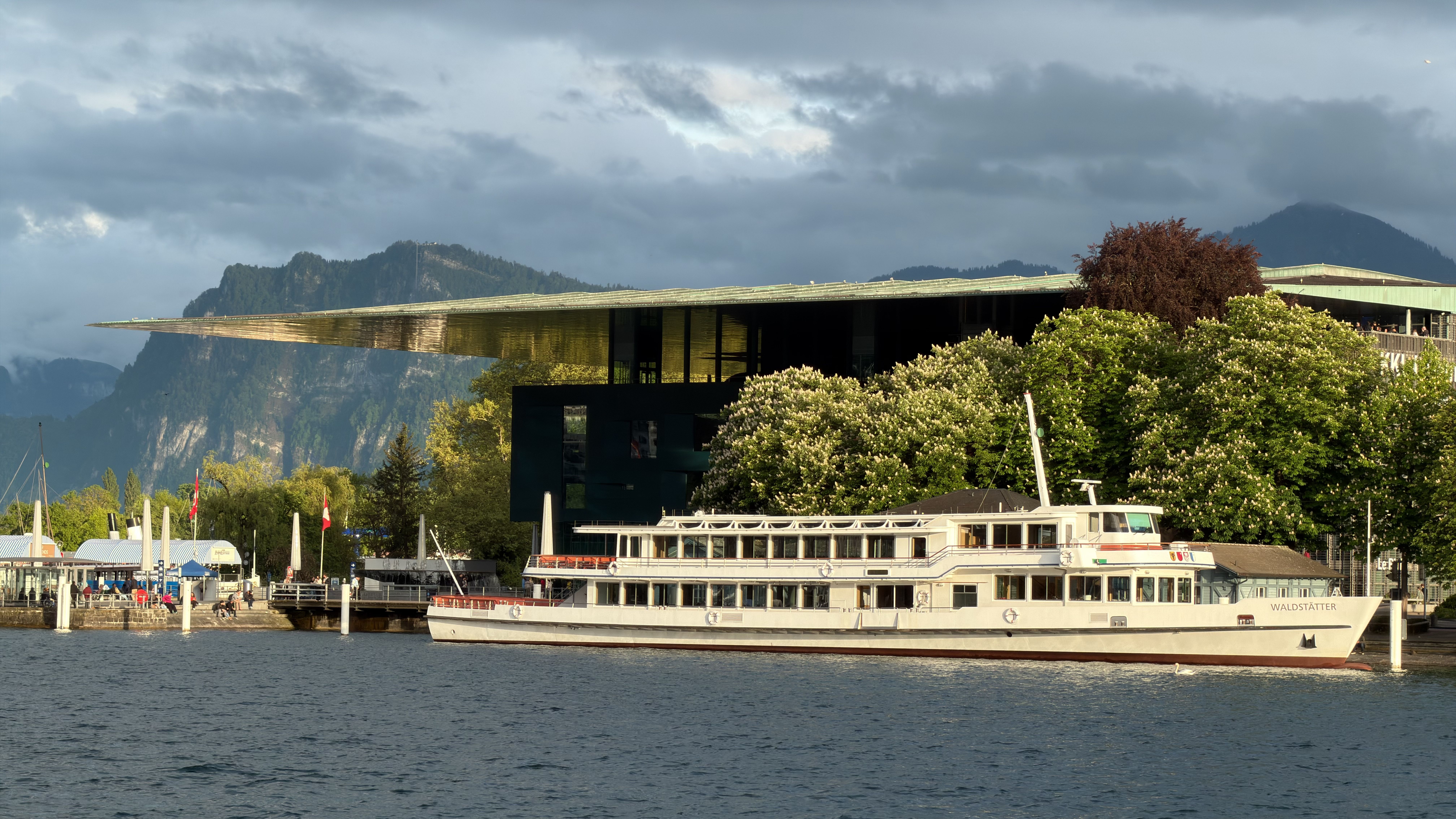 Picturesque Lake Lucerne with a classic paddle steamer and modern architecture.