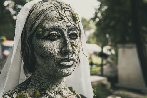 Free Artistic makeup resembling cracked earth in cemetery scene captures haunting beauty. Stock Photo