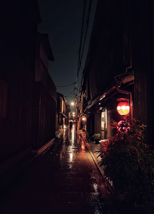 Free Gion district's lantern-lit street in Kyoto's rainy night, evoking mystery and tradition. Stock Photo